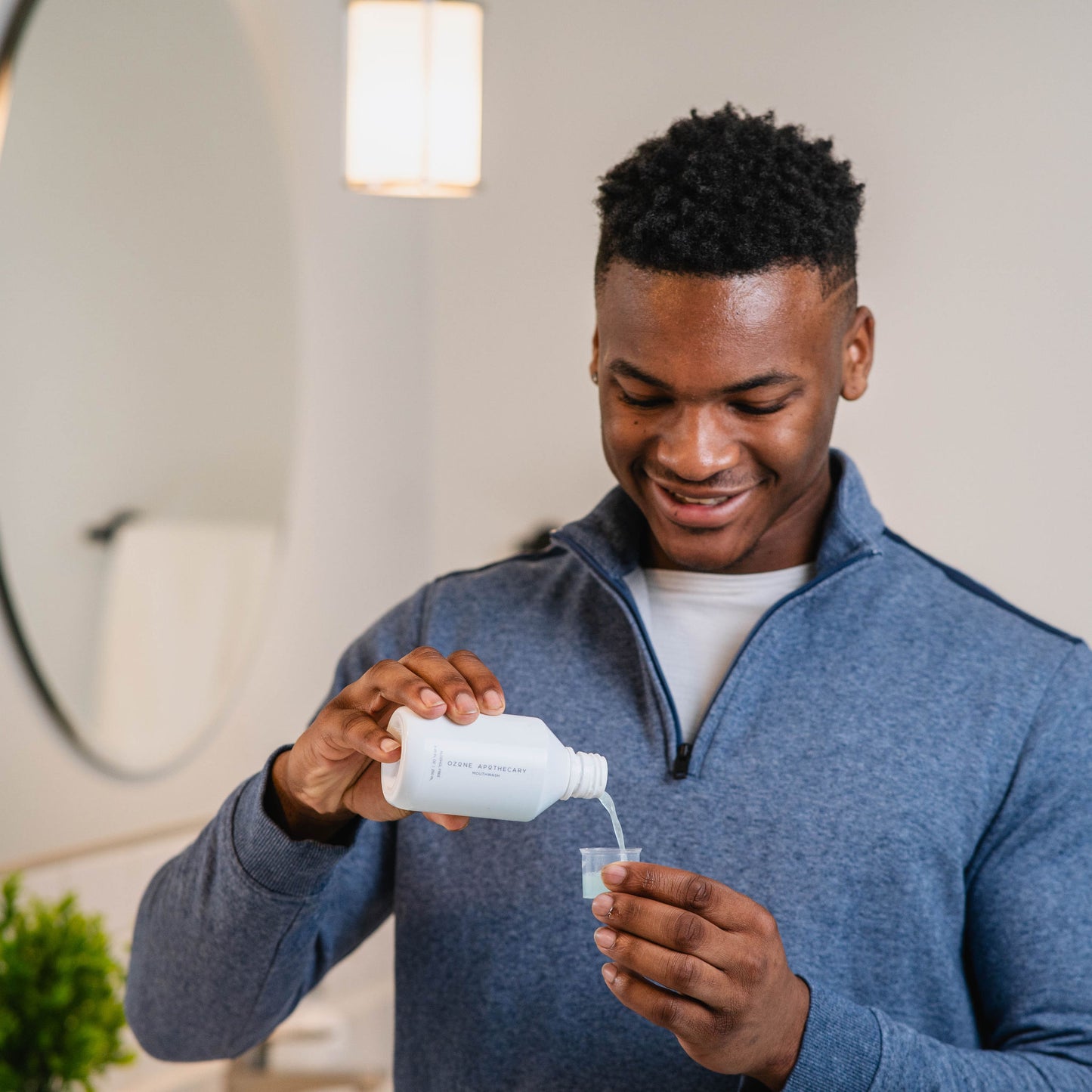 Man pouring ozone mouthwash into small cup