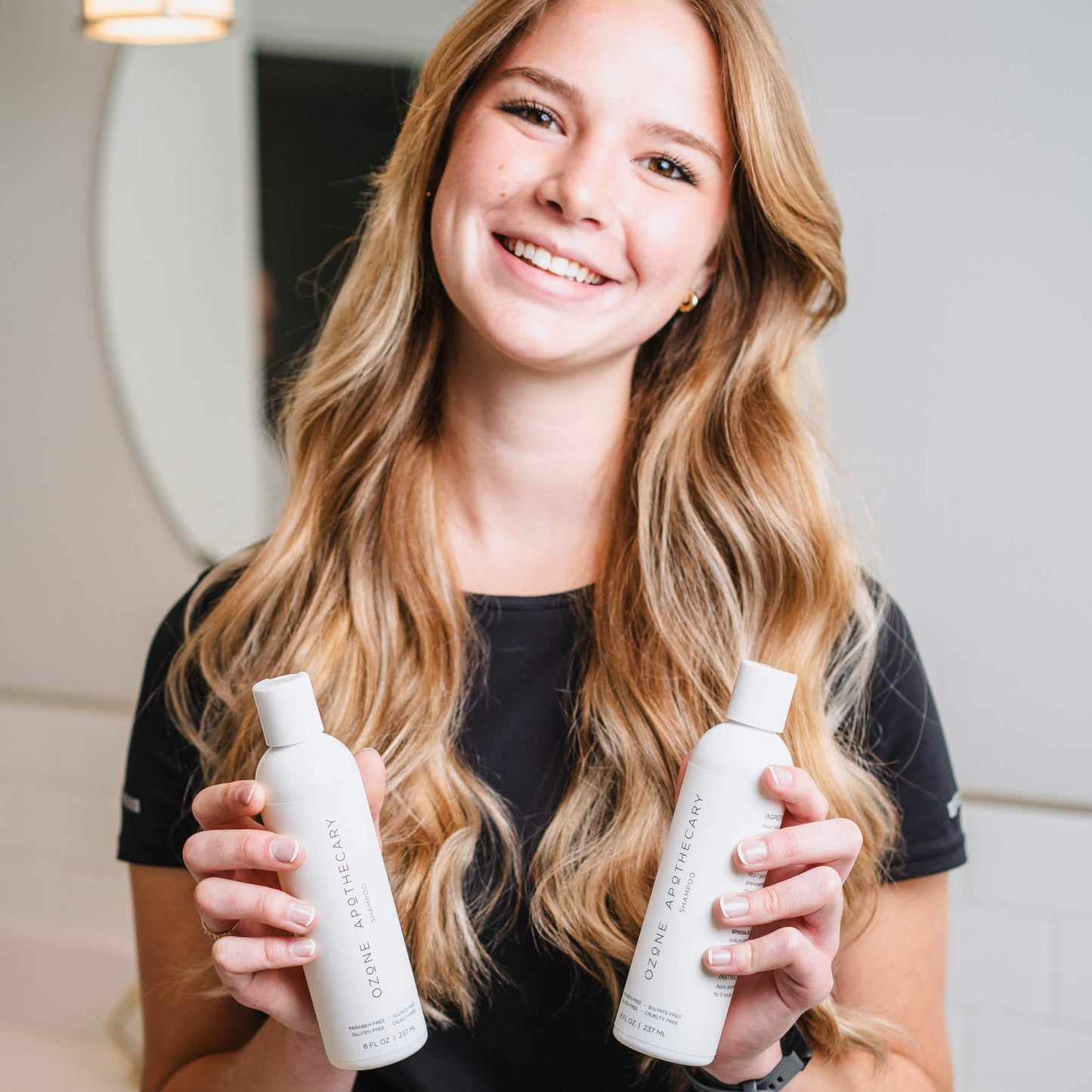 Beautiful girl holding two ozone shampoo bottles