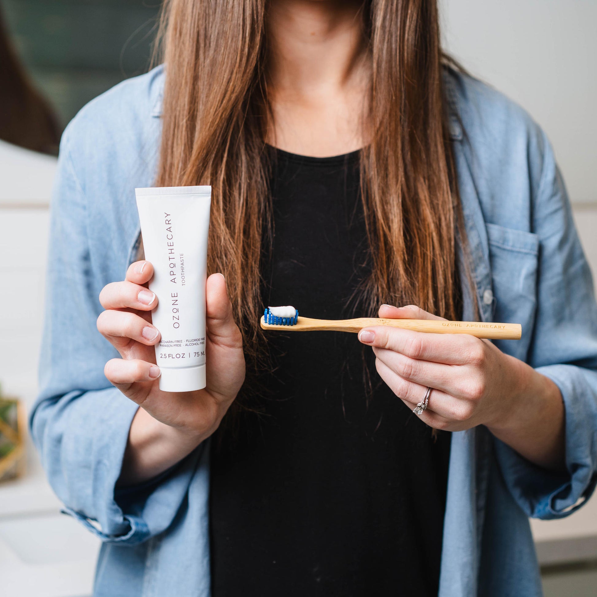 Ozone toothpaste and toothbrush in woman's hand